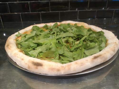 Imagen de una pizza con rucula